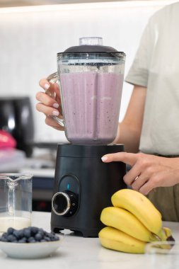 Modern mutfak ortamında sağlıklı bir yaşam tarzı için taze böğürtlen kokteyli hazırlıyorum. Detoks ve diyet kavramı