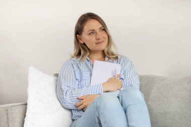 Rahatlamış genç bir kadın evdeki rahat bir kanepede otururken düşüncelerini anlatıyor.