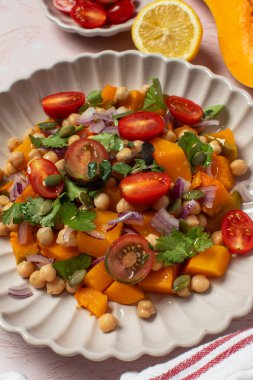 Sonbahar sıcacık bezelye ve kavrulmuş balkabağı salatası taze kiraz domatesleri ve bitkilerle birlikte. Vejetaryen ve sağlıklı salata kavramı