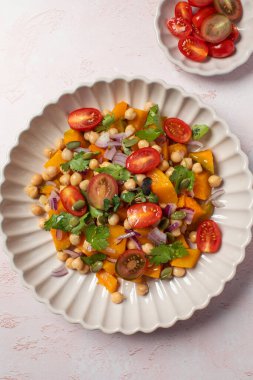 Sonbahar sıcacık bezelye ve kavrulmuş balkabağı salatası taze kiraz domatesleri ve bitkilerle birlikte. Vejetaryen ve sağlıklı salata kavramı