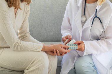 Kadın doktor, ilaç tedavisi gören beyaz kadın hastaya danışmanlık yapıyor. Ev tedavisinde doktorlar danışmanlık