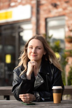 Güzel beyaz kadın yetişkin şehir kafeteryasında kahve ile dışarıda dinleniyor.. 