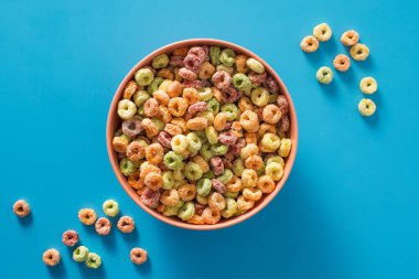 Kahvaltı konsepti için mavi arka planda renkli tahıl kasesi. Kuru kahvaltı.