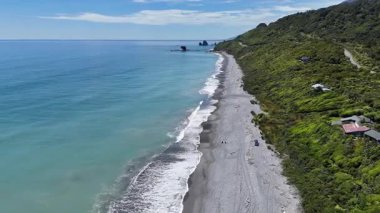 Dalgalar ve yemyeşil yemyeşil verimli kıyı manzaralı, Yeni Zelanda 'nın batı kıyısı. Seyahat kavramı