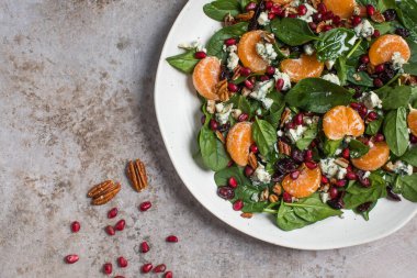 Taze ıspanak, mandalina, nar ve çam fıstığından oluşan iştah açıcı bir salata. Üst Manzara. Boşluğu kopyala