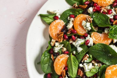 Taze ıspanak ve narlı turunçgil salatası ve sağlıklı yemek için mavi peynir. Vejetaryenler için bayram ve Noel salatası