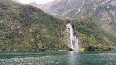 Sudan gelen şelalenin resimli görüntüsü. Milford Sound, Fiordland Ulusal Parkı, Güney Adası, Yeni Zelanda 'da tekne gezisi..
