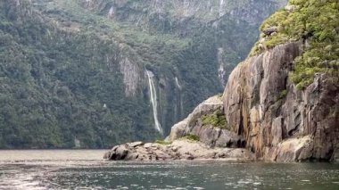 Sudan gelen şelalenin resimli görüntüsü. Milford Sound, Fiordland Ulusal Parkı, Güney Adası, Yeni Zelanda 'da tekne gezisi..