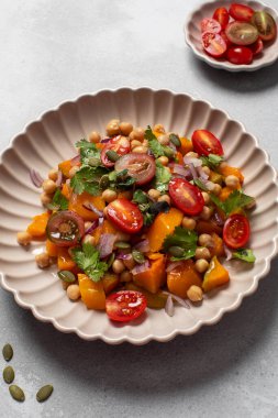 Çeri domatesli ve nohutlu canlı tereyağlı kabak salatası. Vegan ve sağlıklı yemek kavramı