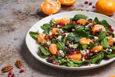 Taze ıspanak, mandalina, nar ve çam fıstığından oluşan iştah açıcı bir salata. Üst görünüm