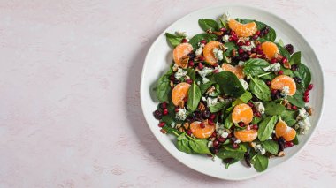 Taze ıspanak ve narlı turunçgil salatası ve sağlıklı yemek için mavi peynir. Vejetaryenler için bayram ve Noel salatası. Boşluğu kopyala