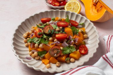 Çeri domatesli ve nohutlu canlı tereyağlı kabak salatası. Vegan ve sağlıklı yemek kavramı