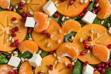 Taze hurma, turunçgil salatası, ıspanak, feta ve nar. Kış salatası. Noel salatası konsepti. 