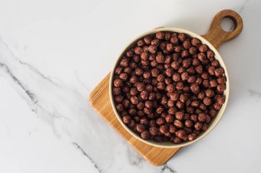 Kahvaltı ve atıştırmalık fikirler için mutfak tezgahında bir kase çikolatalı gevrek. Kuru kahvaltı kavramı. Boşluğu kopyala