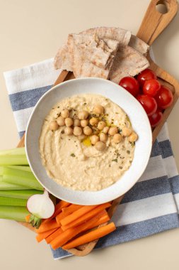 Tahta bir kasede taze humus, içinde pide, kereviz ve havuç var. Nohut yemekleri, vejetaryen yemekleri. Sağlıklı yemek.