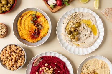 Tabak ve kâse içinde farklı türde humus. Pancar, balkabağı, nohut ve fasulye humusu. Sağlıklı ve vejetaryen kavramı.