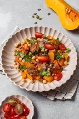 Sonbahar sıcacık bezelye ve kavrulmuş balkabağı salatası taze kiraz domatesleri ve bitkilerle birlikte. Vejetaryen ve sağlıklı salata kavramı