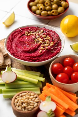 Tahtadaki pancarlı humus taze sebzeler, kereviz, havuç, pide ve zeytin. Sağlıklı ve vejetaryen gıda konsepti.