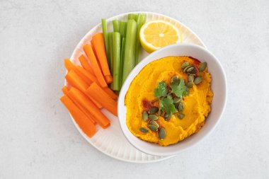 Balkabağı humuslu, havuçlu, kerevizli ve limonlu sağlıklı vejetaryen atıştırmalıkları. Sağlıklı gıda kavramı