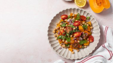 Taze nohut ve domatesli balkabağı salatası ve sağlıklı beslenmek için bitkiler. Sonbahar salatası. Sağlıklı ve vejetaryen yemeği kavramı. Boşluğu kopyala