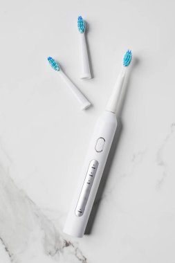 Ultrasonik beyaz diş fırçası, arka planda yeri doldurulabilir başlıklar. Diş sağlığı için elektrikli diş fırçası. Ağız ve diş sağlığı kavramı