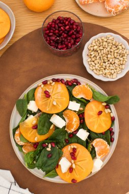 Taze hurma ve çam fıstıklı ıspanak salatası. Kış yemeği kavramı. Boşluğu kopyala