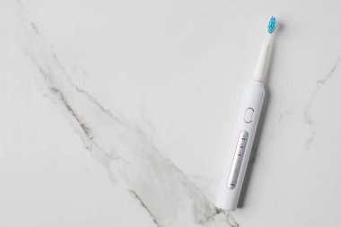 Hafif arka planda ultrasonik beyaz diş fırçası. Diş sağlığı için elektrikli diş fırçası. Ağız ve diş sağlığı konsepti. Boşluğu kopyala