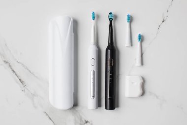 Etkili ağız bakımı için aksesuarlı iki elektrikli diş fırçası ve diş ipi. Ağız temizliği kavramı. 