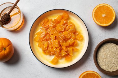 İçinde dilimlenmiş balkabağı, bal ve portakal suyu olan sağlıklı bir tatlı. Sağlıklı balkabağı yemeği konsepti.