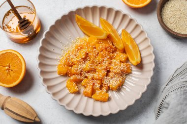 İçinde dilimlenmiş balkabağı, bal ve portakal suyu olan sağlıklı bir tatlı. Sağlıklı balkabağı yemeği konsepti.