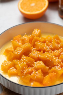 İçinde dilimlenmiş balkabağı, bal ve portakal suyu olan sağlıklı bir tatlı. Sağlıklı balkabağı yemeği konsepti.