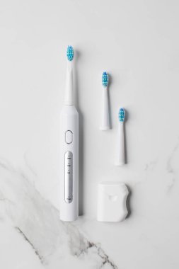 Değiştirilebilir başları ve diş ipiyle beyaz ultrasonik diş fırçası. Ağız temizliği için elektrikli diş fırçası. Oral ve diş bakımı kavramı