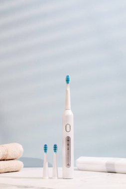 Mavi arka planda yeri doldurulabilir başlıklı ultrasonik beyaz diş fırçası. Diş sağlığı için elektrikli diş fırçası. Ağız ve diş sağlığı kavramı