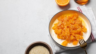 İçinde dilimlenmiş balkabağı, bal ve portakal suyu olan sağlıklı bir tatlı. Sağlıklı balkabağı yemeği kavramı. Boşluğu kopyala