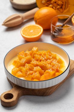 İçinde dilimlenmiş balkabağı, bal ve portakal suyu olan sağlıklı bir tatlı. Sağlıklı balkabağı yemeği konsepti.