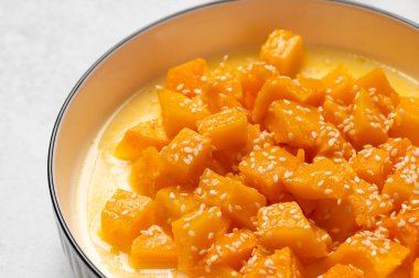 İçinde dilimlenmiş balkabağı, bal ve portakal suyu olan sağlıklı bir tatlı. Sağlıklı balkabağı yemeği konsepti.