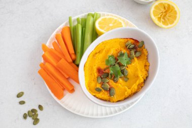 Atıştırmak için taze sebzeli ve kabak tohumlu sağlıklı balkabağı humusu. Sağlıklı gıda kavramı