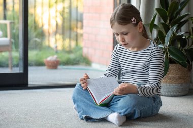 Evinde, pencerenin yanında kitap okuyan sevimli bir kız. Eğitim kavramı
