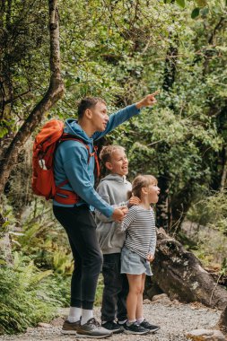 Doğa yürüyüşünde aile macerası, ebeveynler ve çocukların açık havada keşfe çıkması. Seyahat kavramı. Yeni Zelanda