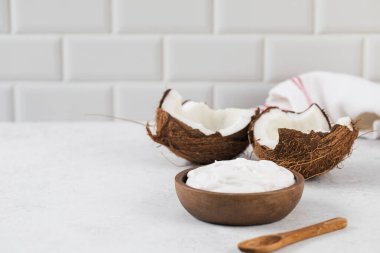 Tahta kaşık ve hindistan cevizli tahtadan bir kasede taze hindistan cevizli yoğurt. Vejetaryen yoğurt kavramı, laktozsuz. Boşluğu kopyala