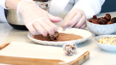 Making healthy date candies, the candies are rolled in cocoa powder. The recipe, step by step. Step 2
