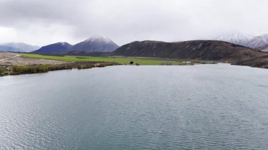 Scenic aerial journey over serene mountain lake and rolling hills in misty weather. New Zealand. Concept of travel and nature