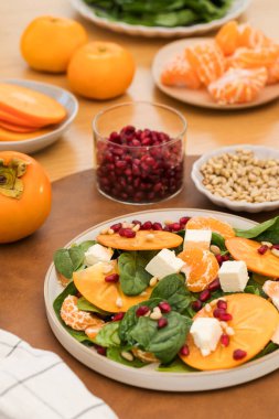 Taze hurma ve çam fıstıklı ıspanak salatası. Kış yemeği kavramı. Boşluğu kopyala