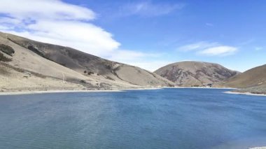 Flying over a clear lake surrounded by hills in New Zealand. The concept of travel and nature.