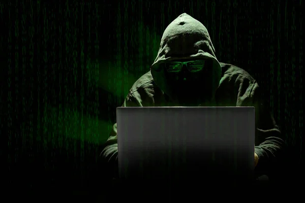 매트릭스 스타일의 컴퓨터 코드의 배경에 노트북으로 사이버 공격을 저지른 디지털 스톡 이미지