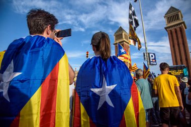 Barselona, Katalonya, İspanya - 11 Eylül 2023: Katalonya Ulusal Günü 'ne katılan genç katılımcılar, arka planda Venedik kuleleriyle birlikte bağımsızlık bayrağına sarıldı