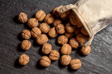 Koyu bir arka plana serpilmiş ceviz içerikli çuval bezi manzarası