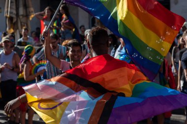 Barselona, İspanya - 15 Temmuz 2023: Barcelona 'daki eşcinsel onur yürüyüşünde katılımcılar gökkuşağı bayrağıyla sarmalandılar. Sahne, LGBTQ topluluğunun çeşitlilik ve şenlik ruhunu gösteriyor.