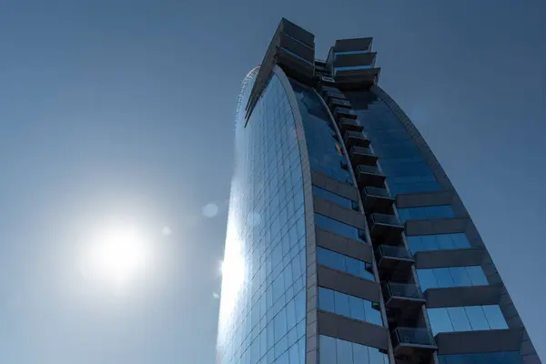 Barcelona, İspanya 08 Ağustos 2024: W Barcelona Oteli, güneşle yan yana aydınlatılmış, mavi gökyüzü ve Hotel Vela olarak bilinen gezinti alanı tarafından çerçevelenmiş..