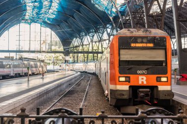 Turuncu tren tarihi bir tren istasyonuna varıyor. Yolcular gelişlerini bekliyor. İstasyonun mimarisi muhteşem..